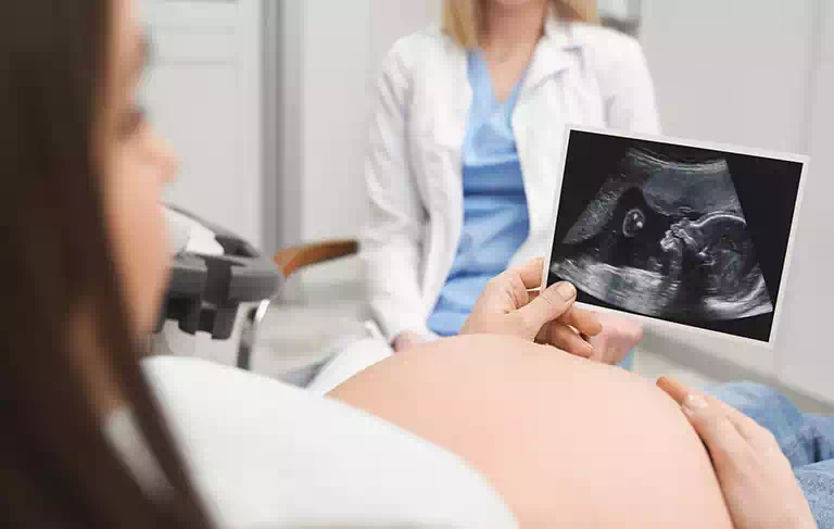 Kobieta oglądająca zdjęcie USG dziecka
